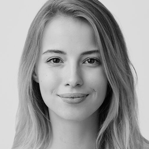 Schwarz-weiß-Bild einer jungen Frau, die mit einem sanften Ausdruck in die Kamera blickt